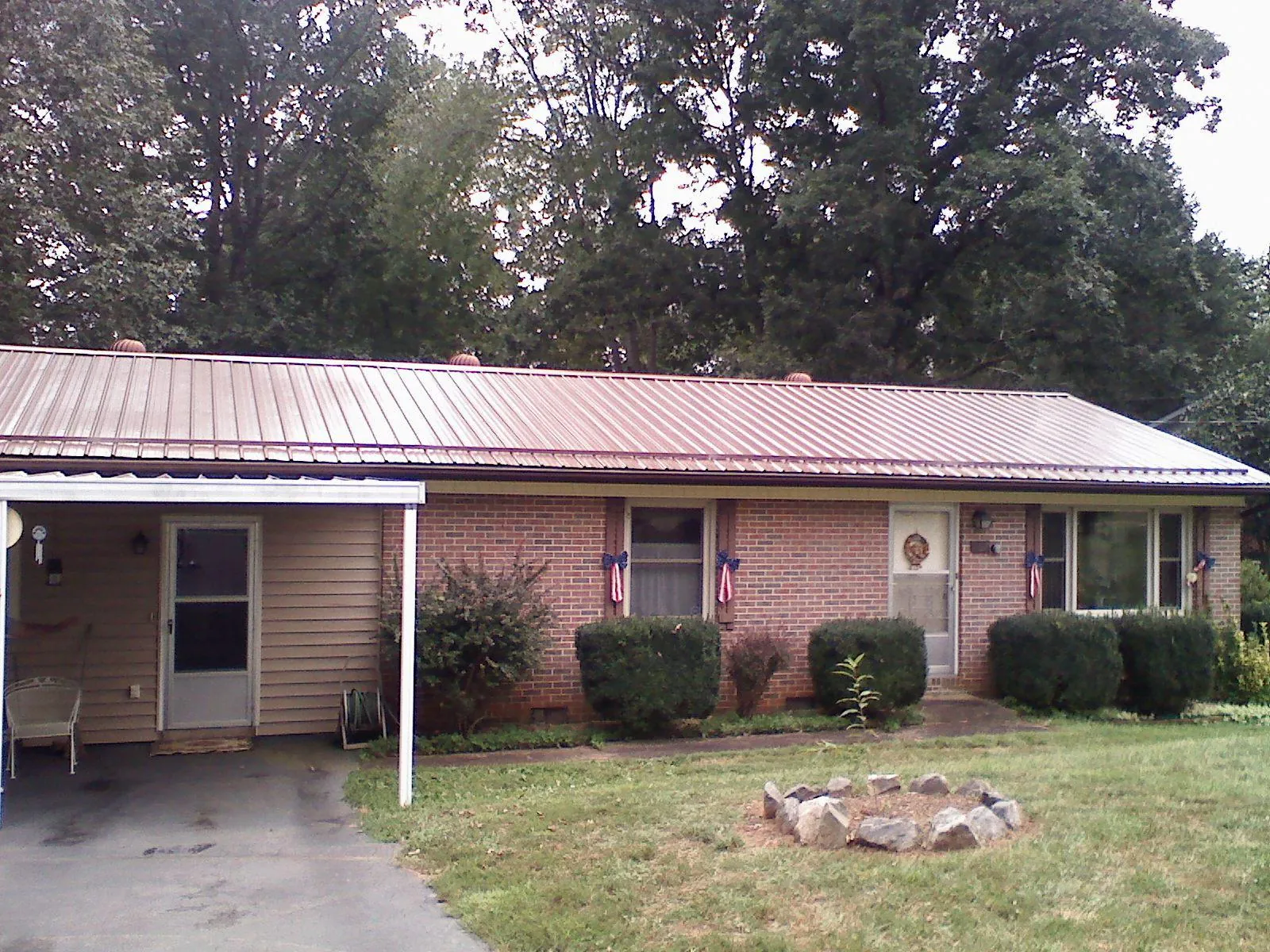 Bronze metal roof and carport on a brick ranch home — Roof Repair work by our crew in Montrose